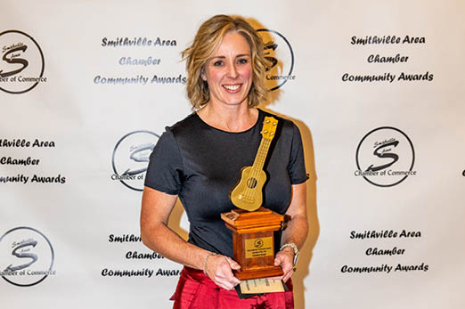 A woman in red pants is holding a trophy. AI generated content