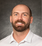 A man with a beard and mustache is smiling for the camera. AI generated content