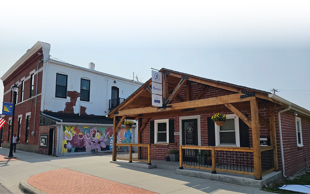 A small building with a wooden porch and a sign on the side. AI generated content