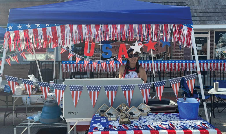 A woman is standing under a blue tent with an American flag design. The tent is set up in front of a building. AI generated content