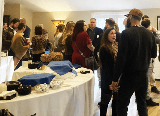 A group of people are standing around a table with food and drinks. AI generated content