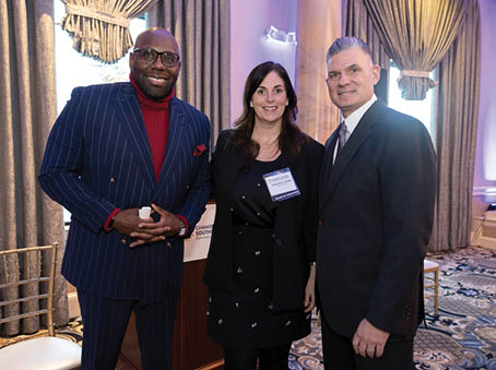 Three people are standing together, two men and a woman. They are all dressed in suits and ties, with one of the men wearing a red tie. The woman is wearing a name tag. They appear to be posing for a picture. AI generated content
