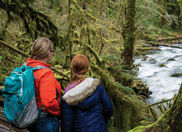 A mother and daughter hike along the South Fork Alsea River near the Alsea Falls.