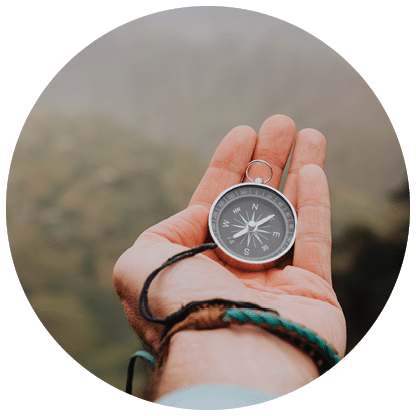 Starched palm with compass  Looking at the compass to figure out right direction  Foggy valley and mountains in background  Santo Antao  Cape Cabo Verde 