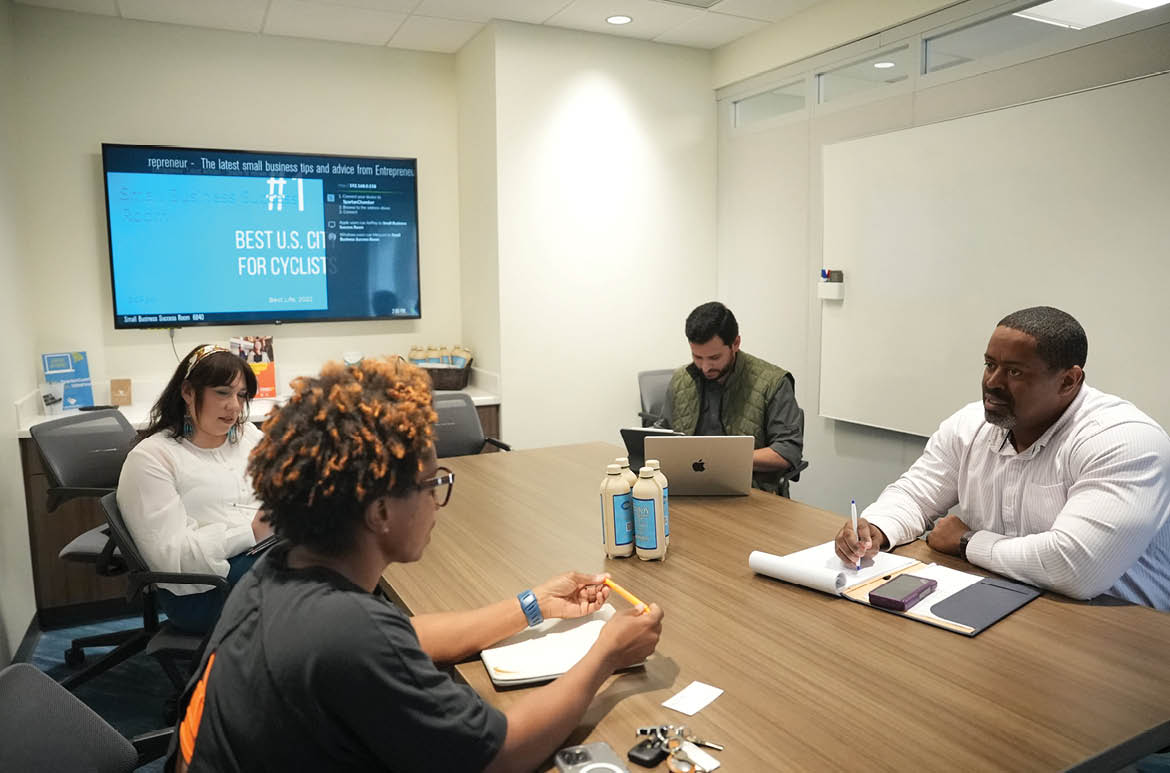 A group of people are sitting in a conference room, watching a presentation on a large screen. AI generated content