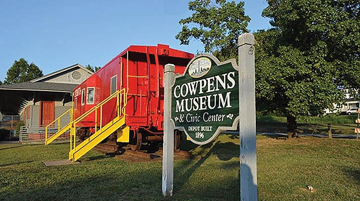 A red train car is parked in front of a museum sign. AI generated content