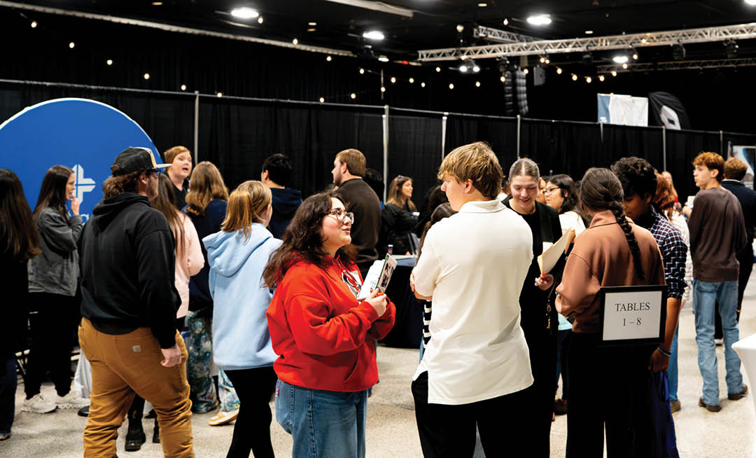 A group of people are standing in a room, socializing and enjoying themselves. AI generated content