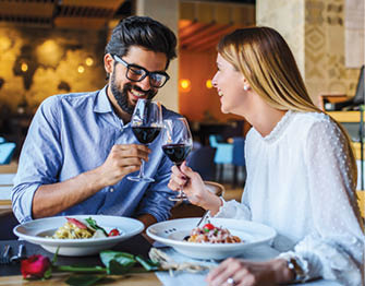 Loving couple enjoying lunch in the restaurant, eating paste and drinking red wine. Lifestyle, love, relationships, food concept