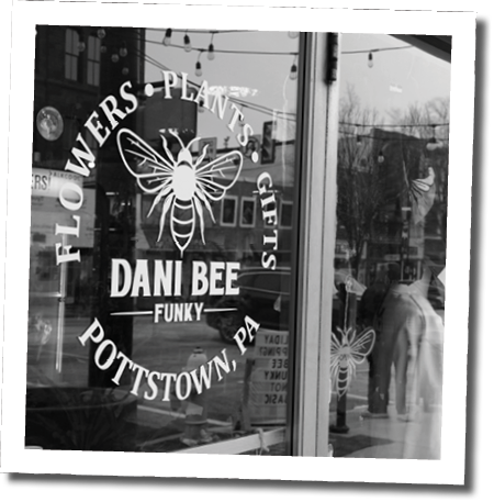 A window display for a flower shop with a sign that says “Dani Bee's Potts Town Funky". AI generated content