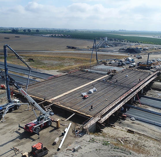 A large construction site with a crane and a man working on a bridge. AI generated content