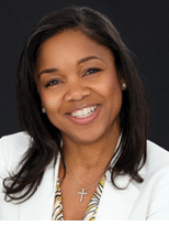 A woman wearing a white jacket and a yellow and black striped shirt. Description generated by AI