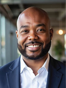 A man wearing a suit and tie smiling. Description generated by AI