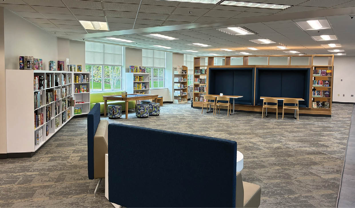 A large room with a blue carpet and a white table. Description generated by AI