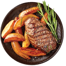 A plate of food with meat, potatoes, and herbs. Description generated by AI