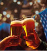 Close up image of hands holding glasses of beer and clinking after toast. Old friends sitting in bar and celebrating beginning of football season. Concept of Beer Fest, party, taste, traditions.
