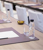 Paper, pencil, water bottle, glass on the table in the seminar room background