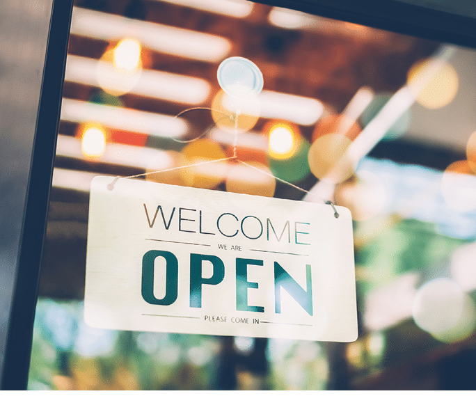 A business sign that says Open on cafe or restaurant hang on door at entrance. Vintage color tone style.