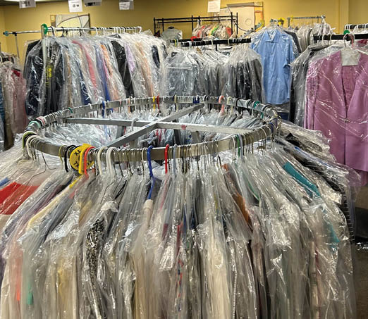 A large display of clothing in a store, including shirts and pants, is arranged in a circular fashion. AI generated content