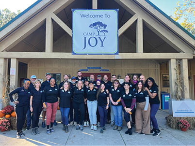 A group of people wearing black shirts and posing for a photo in front of a building. AI generated content