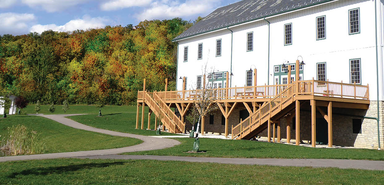 A white building with a porch and stairs. Description generated by AI