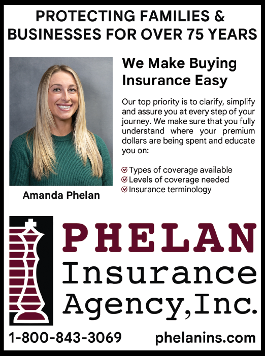 A woman smiling in front of a sign for Phelan Insurance. Description generated by AI