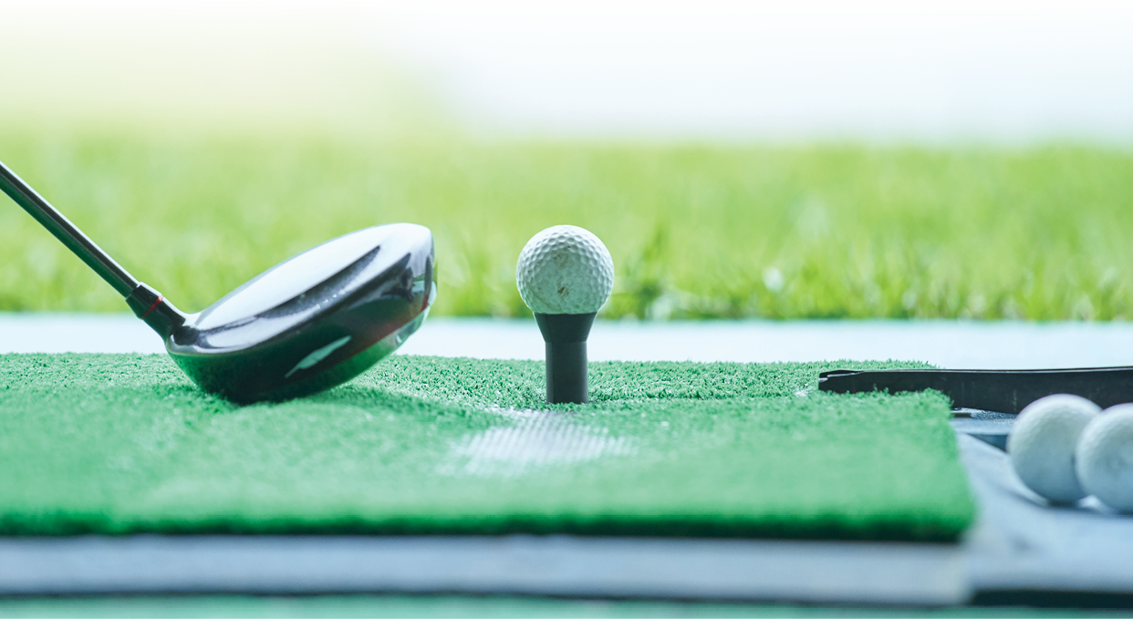 The feet of a man practicing at a golf course