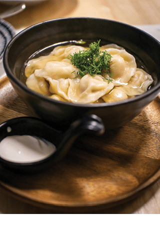 A bowl of soup with a spoon and a garnish of parsley. AI generated content