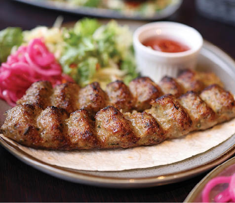A plate of food with meat and vegetables, including onions and lettuce. AI generated content