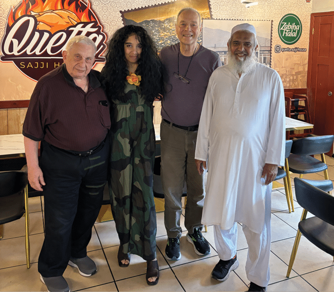 A group of people posing for a picture in a restaurant. AI generated content