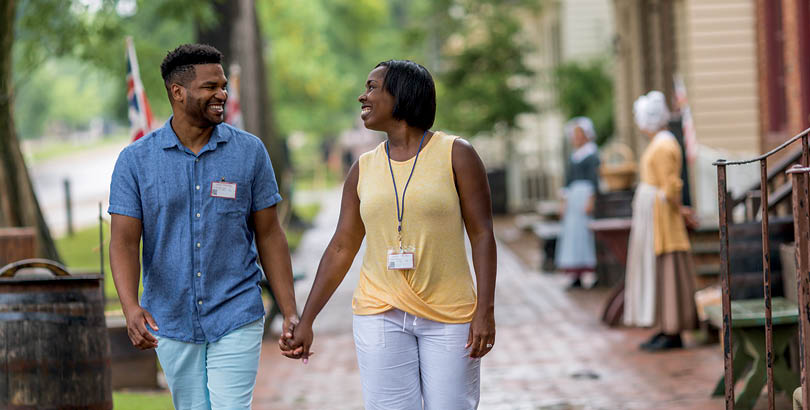 A man and woman walking down a sidewalk. Description generated by AI
