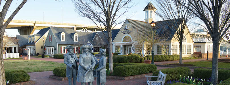 A statue of three men is in a courtyard. Description generated by AI