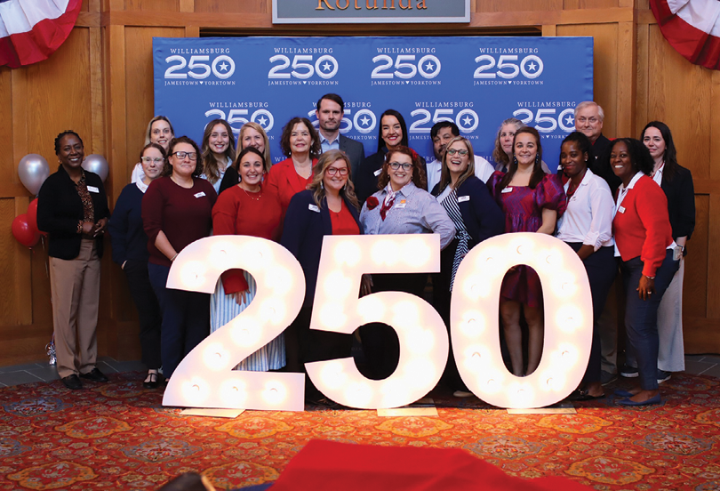 A group of people standing in front of a 250 sign. Description generated by AI