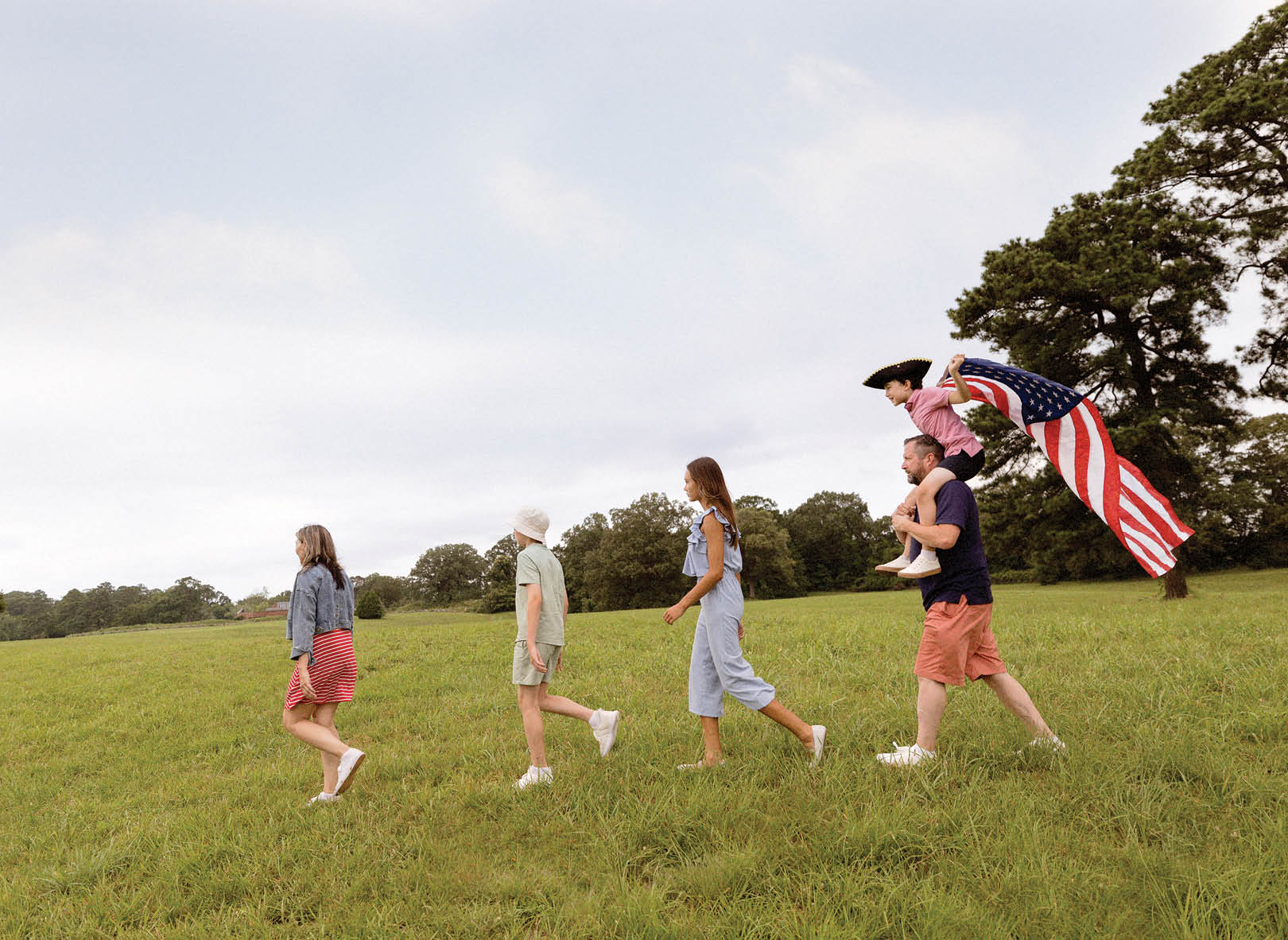 A group of people walking in a field. Description generated by AI