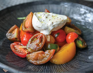 A plate of food with tomatoes, onions, and cheese. Description generated by AI