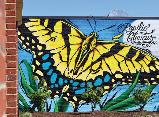 A yellow and black butterfly painted on a wall. Description generated by AI