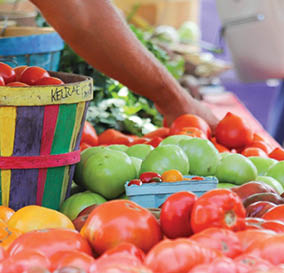 A person is reaching into a basket of fruit. Description generated by AI