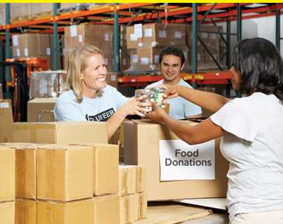 Volunteers Collecting Food Donations For Charity In Warehouse