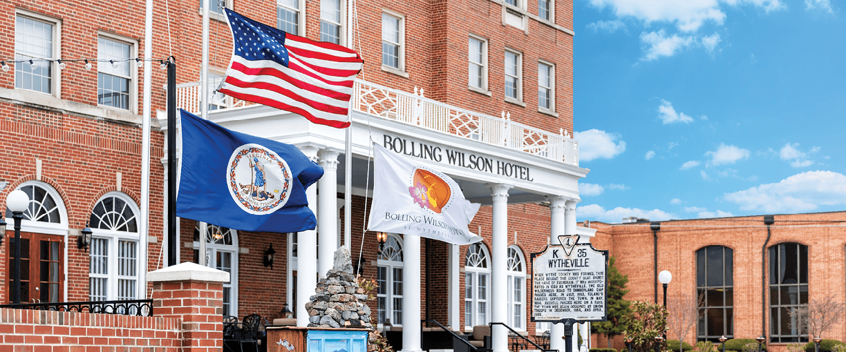 Wytheville, USA - April 19, 2018: Small town village signs flags for historic famous Bolling Wilson boutique hotel in southern south Virginia, historic brick buildings
