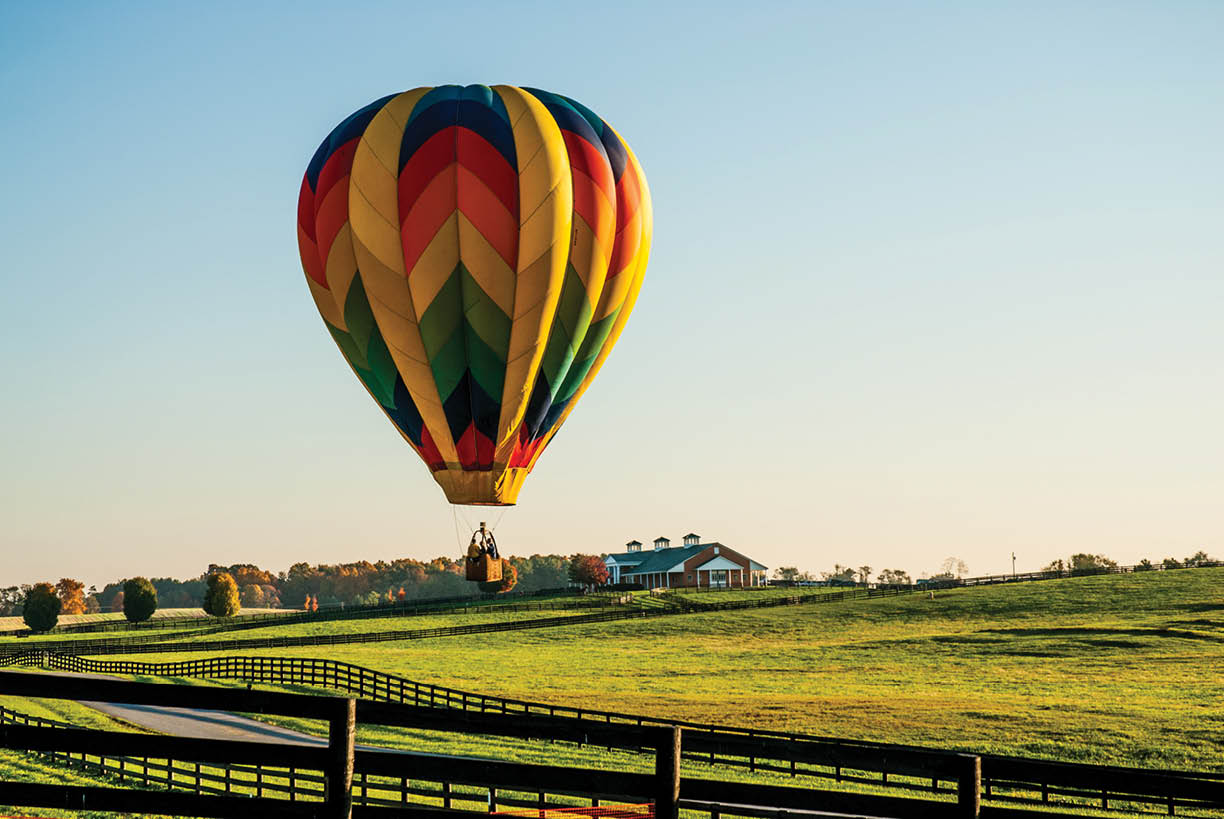A hot air balloon flying over farmland in rural Virginia in the fall.