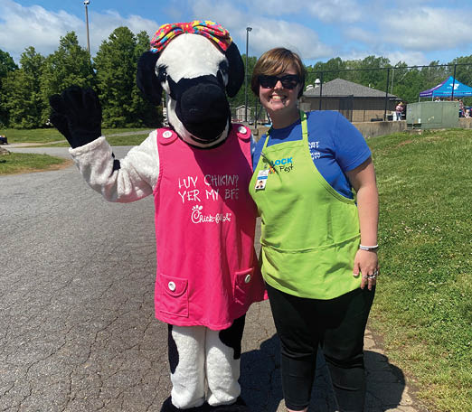 A woman and a man in a cow costume pose for a picture. AI generated content