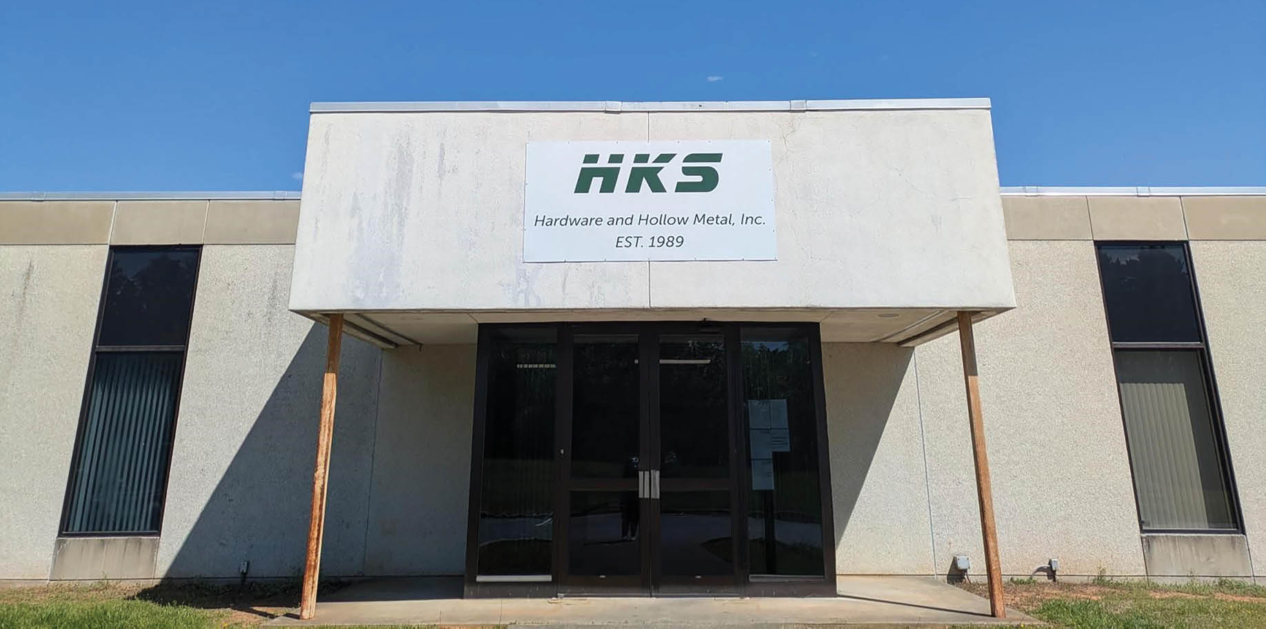 A white building with a green sign on it. AI generated content
