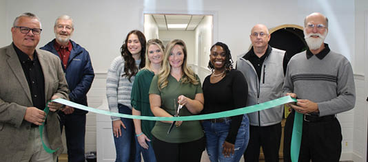 A group of people are standing in front of a ribbon, getting ready to cut it. AI generated content