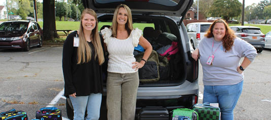 Three women are standing next to a car with their luggage. AI generated content