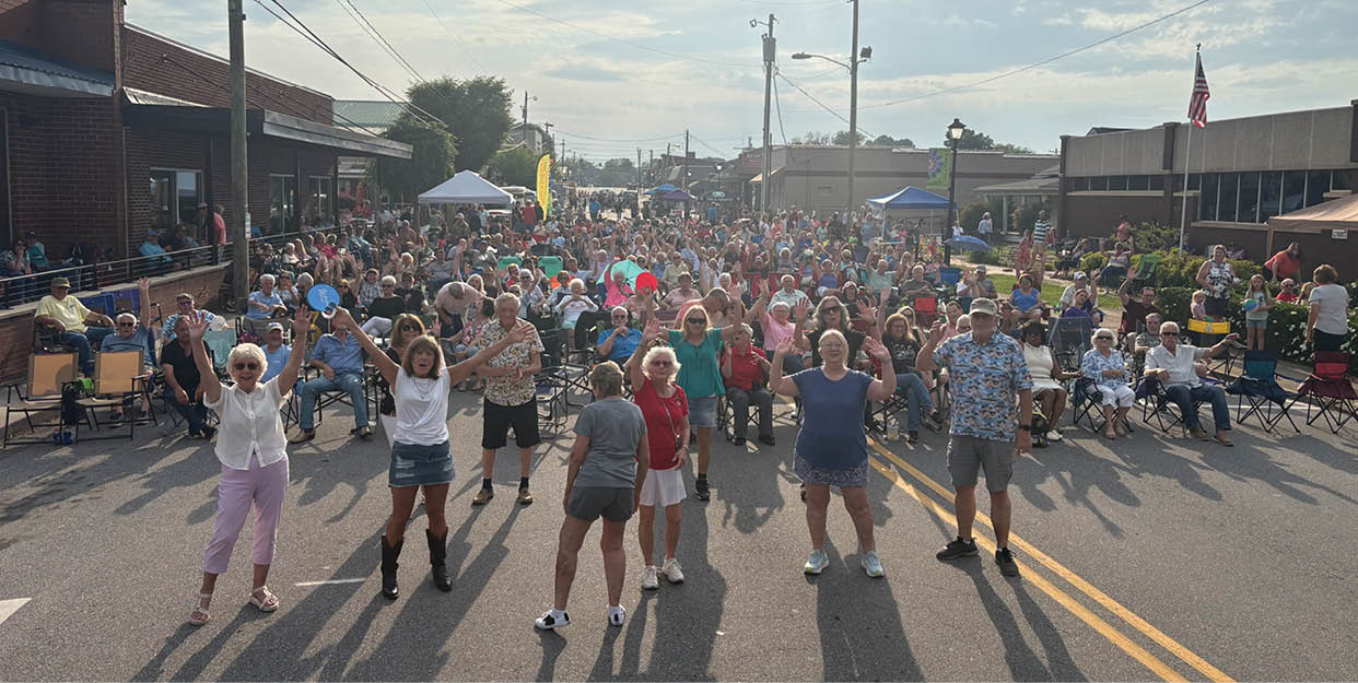A large group of people are dancing in the street, with some of them wearing shorts. AI generated content
