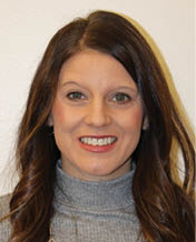 A woman with long hair and a grey shirt smiling for the camera. AI generated content