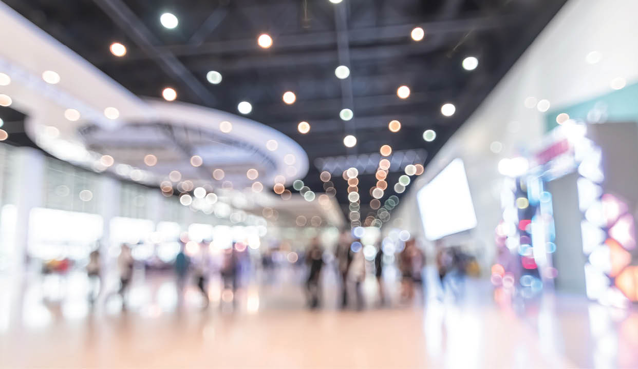 Exhibition event hall blur background of trade show business, world or international expo showcase, tech fair, with blurry exhibitor tradeshow booth displaying product with people crowd