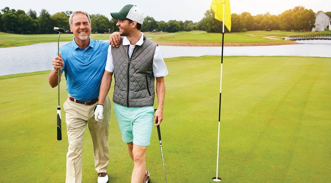 Happiness is a long walk with a putter. two friends out playing golf together in their free time