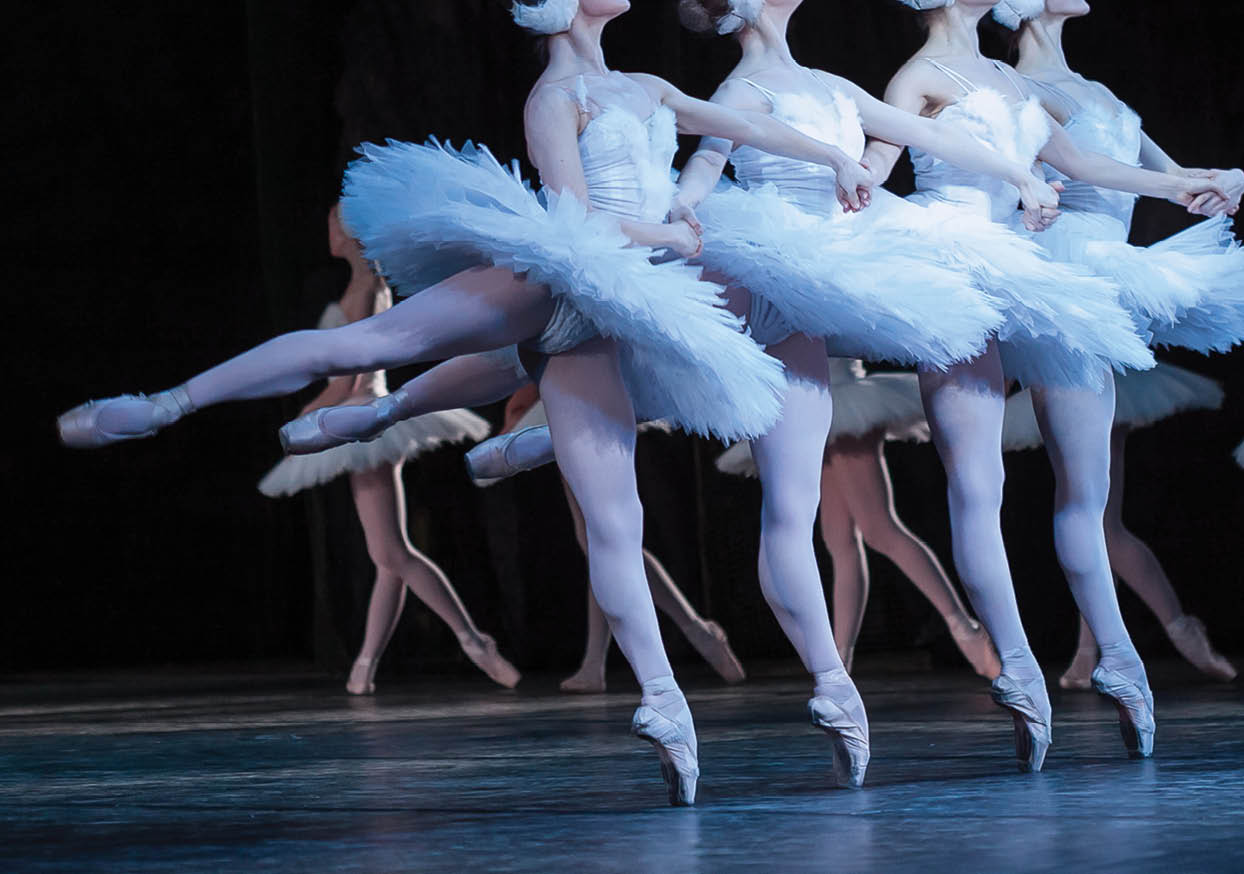 beauty, agility, dancing concept. arm in arm four elegant and graceful female ballet dancers, playing the roles of petite swans, moving, dancing and jumping synchronously