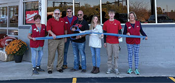 A group of people are standing in front of a building with a red sign that says “Lakeview Ace". AI generated content