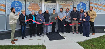 A group of people are standing in front of a building, holding a ribbon and getting ready to cut it. AI generated content